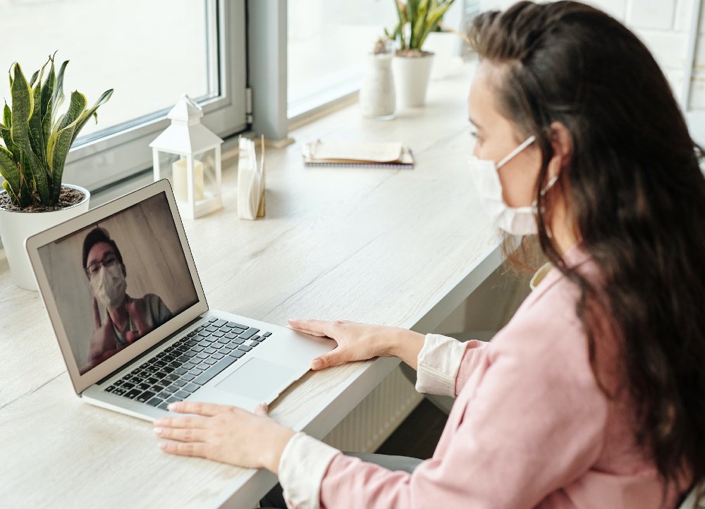 A therapist conducting a virtual psychotherapy session with a patient in Palm Springs via a secure video call.