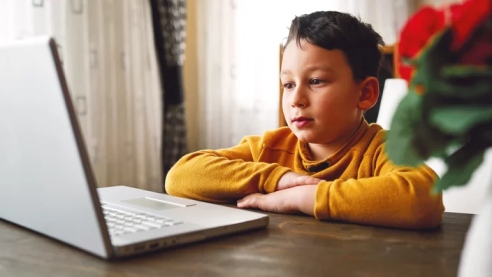 A young teen in California in an online session with a child psychiatrist on a laptop.