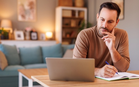 Person attending virtual schizophrenia therapy session on laptop in California